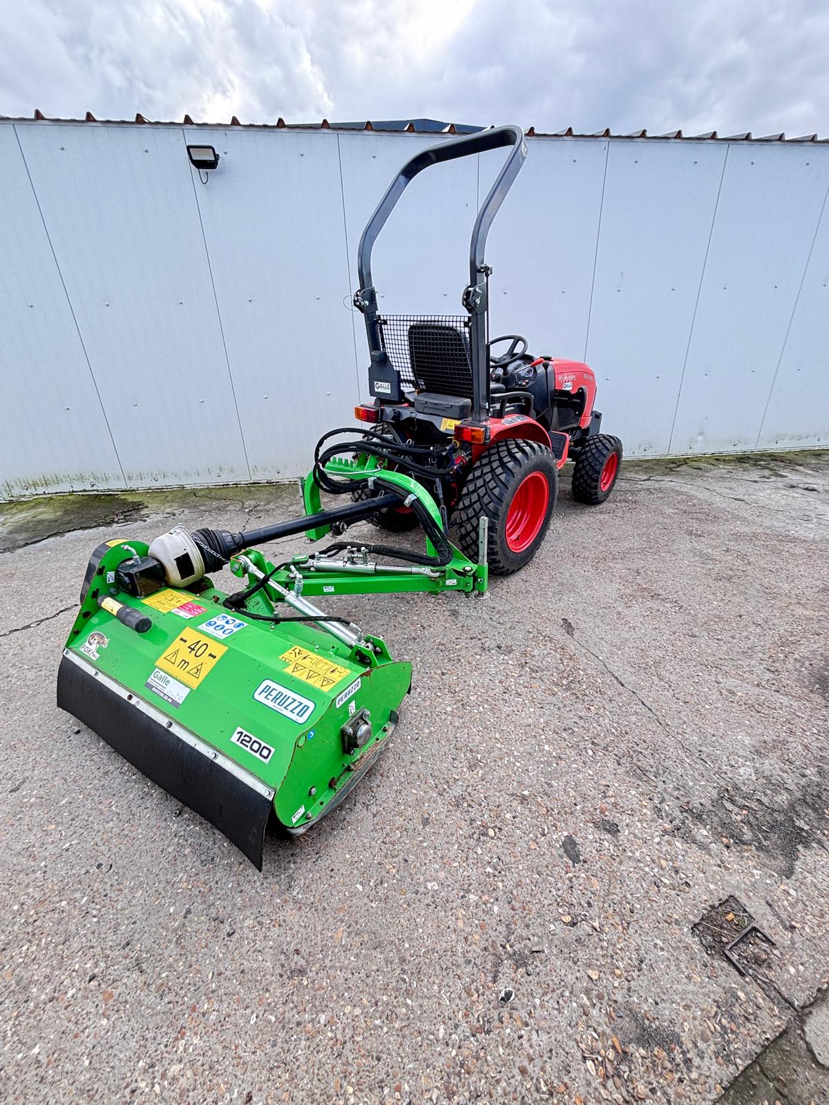 rood kubota trekker met peruzzo maaidek in industriële omgeving tuinbouwmachines galle verhuur verkoop en onderhoud